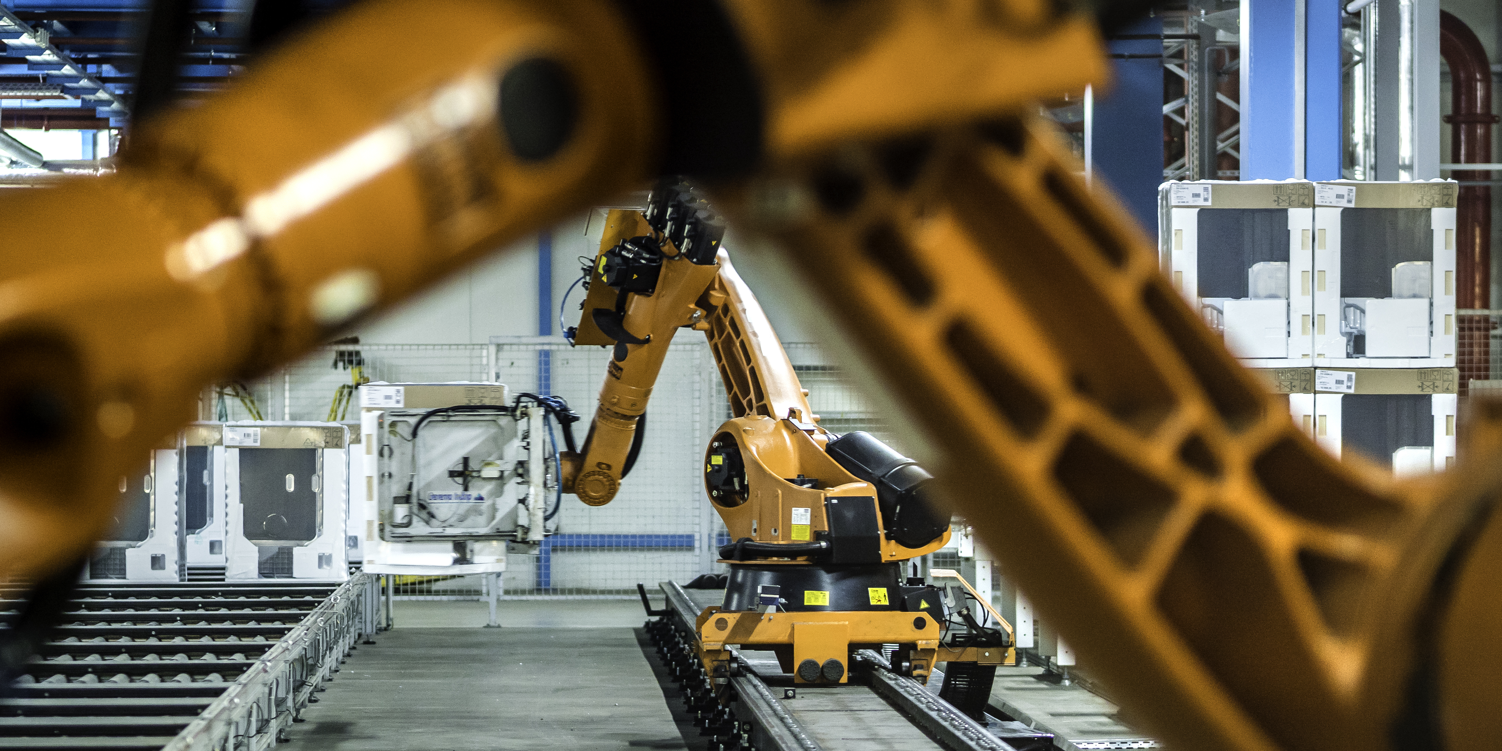 Photo of two robotic arms doing work in a factory assembly line