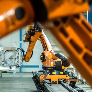 Photo of two robotic arms doing work in a factory assembly line