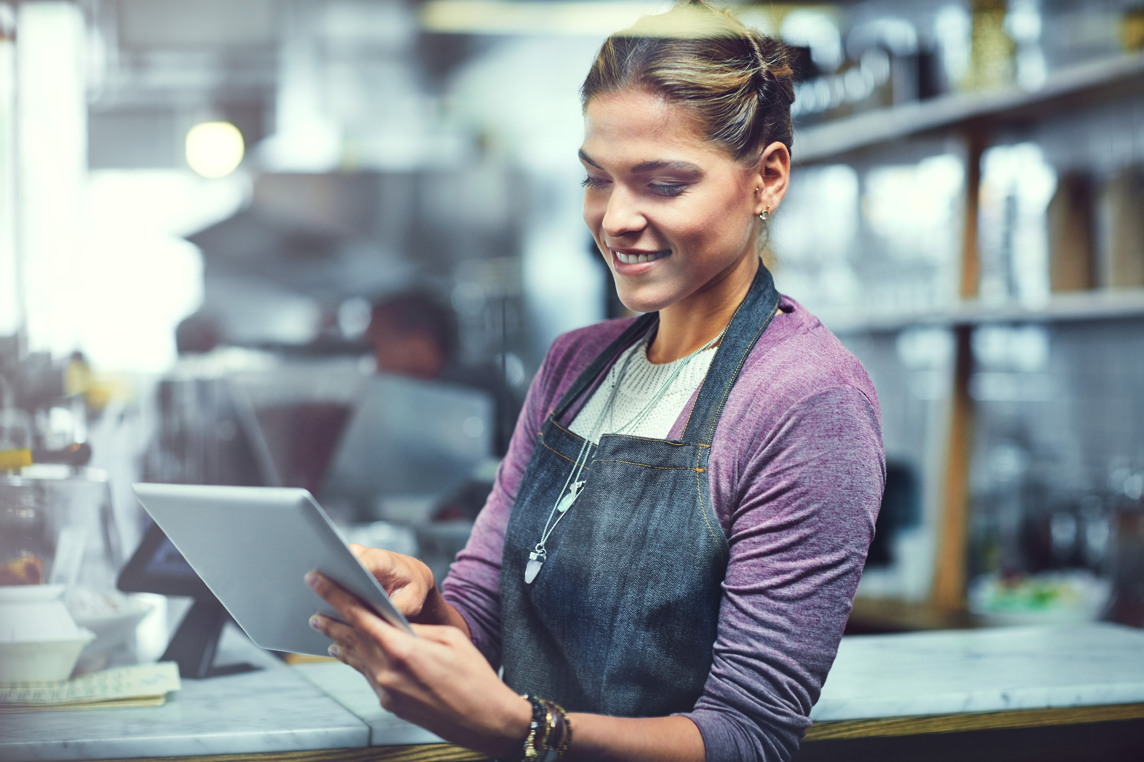 Shot of a young woman using a digital tablet in the store that she works at