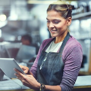 Shot of a young woman using a digital tablet in the store that she works at