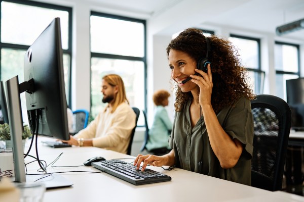 Side view of a woman working with computer in a coworking call center